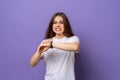 Young brunette woman wearing casual white t shirt in hurry pointing to watch time, impatience, upset and angry for deadline delay Royalty Free Stock Photo