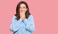 Young brunette woman wearing casual winter sweater laughing and embarrassed giggle covering mouth with hands, gossip and scandal Royalty Free Stock Photo