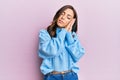 Young brunette woman wearing casual winter sweater over pink background sleeping tired dreaming and posing with hands together Royalty Free Stock Photo