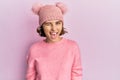 Young brunette woman wearing cute wool cap winking looking at the camera with sexy expression, cheerful and happy face Royalty Free Stock Photo