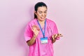 Young brunette woman wearing doctor uniform and stethoscope disgusted expression, displeased and fearful doing disgust face