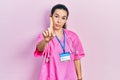 Young brunette woman wearing doctor uniform and stethoscope pointing with finger up and angry expression, showing no gesture Royalty Free Stock Photo