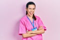 Young brunette woman wearing doctor uniform and stethoscope standing with arms crossed winking looking at the camera with sexy Royalty Free Stock Photo