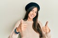 Young brunette woman wearing french look with beret approving doing positive gesture with hand, thumbs up smiling and happy for Royalty Free Stock Photo