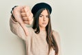 Young brunette woman wearing french look with beret looking unhappy and angry showing rejection and negative with thumbs down Royalty Free Stock Photo