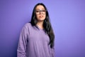 Young brunette woman wearing glasses over purple isolated background Relaxed with serious expression on face Royalty Free Stock Photo