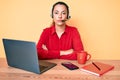 Young brunette woman wearing operator headset at the call center office with serious expression on face Royalty Free Stock Photo
