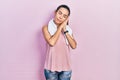 Young brunette woman wearing sportswear and towel sleeping tired dreaming and posing with hands together while smiling with closed Royalty Free Stock Photo