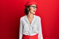 Young brunette woman wearing stewardess style and glasses looking away to side with smile on face, natural expression