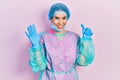 Young brunette woman wearing surgeon uniform and medical mask showing and pointing up with fingers number six while smiling Royalty Free Stock Photo