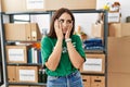 Young brunette woman wearing volunteer t shirt at donations stand tired hands covering face, depression and sadness, upset and