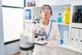 Young brunette woman working at scientist laboratory with microscope looking at the camera blowing a kiss being lovely and sexy Royalty Free Stock Photo