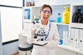 Young brunette woman working at scientist laboratory with microscope winking looking at the camera with sexy expression, cheerful Royalty Free Stock Photo