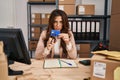 Young brunette woman working at small business ecommerce cutting credit card skeptic and nervous, frowning upset because of Royalty Free Stock Photo