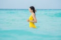 Young brunette woman in yellow one piece swimsuit. Royalty Free Stock Photo