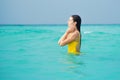 Young brunette woman in yellow one piece swimsuit. Royalty Free Stock Photo