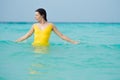 Young brunette woman in yellow one piece swimsuit. Royalty Free Stock Photo