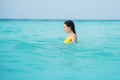 Young brunette woman in yellow one piece swimsuit. Royalty Free Stock Photo