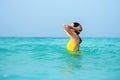 Young brunette woman in yellow one piece swimsuit. Royalty Free Stock Photo