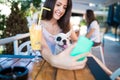 Young woman with her dog in cafe bar