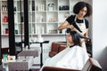 Young brunette woman enjoying professional hairstyling at beauty salon