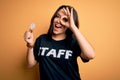 Young brunette worker woman wearing staff t-shirt as uniform showing puzzle piece as teamwork with happy face smiling doing ok Royalty Free Stock Photo