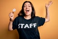 Young brunette worker woman wearing staff t-shirt as uniform showing puzzle piece as teamwork very happy and excited, winner Royalty Free Stock Photo