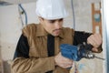Young buider drilling wall with drill perforator Royalty Free Stock Photo