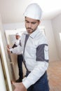 Young builder fitting insulation boards into roof new home Royalty Free Stock Photo