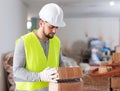 Young builder inspects and stacks bricks on top of each other