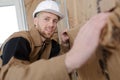 Young builder insulating walls in room Royalty Free Stock Photo