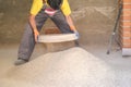 Young builder sieving sand at a construction site.