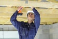 young builder working on wooden roof joist