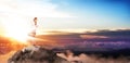 Young buiness woman stands on the top of the mountain.