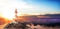 Young buiness woman stands on the top of the mountain.