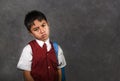 Young bullied abused schoolboy in uniform carrying school bag sad depressed on blackboard feeling a lonely and stressed kid victim Royalty Free Stock Photo