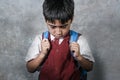 Young bullied abused schoolboy in uniform carrying school bag sad depressed on blackboard feeling a lonely and stressed kid victim Royalty Free Stock Photo