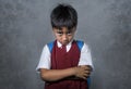 Young bullied abused schoolboy in uniform carrying school bag sad depressed on blackboard feeling a lonely and stressed kid victim Royalty Free Stock Photo