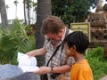 Young Burmese boy with thanaka helps tourist in Myanmar, Burma