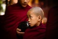 Young Burmese monk at Maha Gandaryon monastery waits in food line.