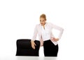 Young busiess woman standing behind the desk leanig on armchair Royalty Free Stock Photo