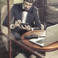 Young businesman working at cafe, using mobile phone