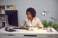 Young business african american woman working on a laptop at office on her workplace. Royalty Free Stock Photo