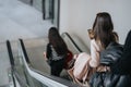 Back view of young business colleagues on an escalator. Capturing the dynamic pace of business life in an urban setting. Royalty Free Stock Photo