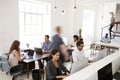 Young business colleagues working in a busy open plan office