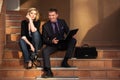 Young business couple with laptop on the steps Royalty Free Stock Photo