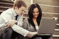 Young business couple with laptop on the steps Royalty Free Stock Photo