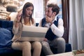 Young business couple looking at the laptop, thinking Royalty Free Stock Photo