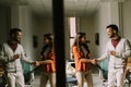 Young business couple standing and handshaking in front of her team at the office