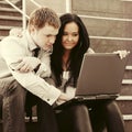 Young business couple using laptop on the steps Royalty Free Stock Photo